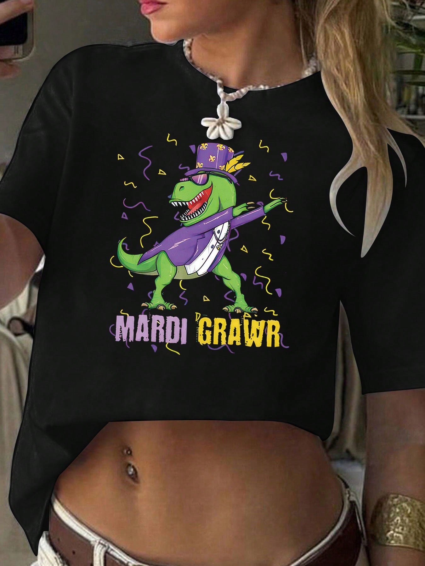 Be ready for a wild and colorful spring and summer with our Festive Mardi Gras Saurus Rex Graphic Tee! This unique shirt features a playful design of a dinosaur celebrating Mardi Gras, adding a fun twist to your wardrobe. Perfect for those looking to let loose and have a good time!