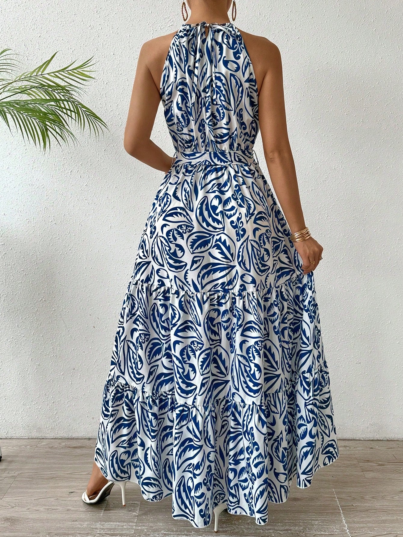 Experience effortless beach elegance with Floral Dream: Plant-Printed Halterneck Maxi Dress. The vibrant plant print and halterneck style combine for a stunning look. Perfect for any beach day or summer event. Let this dress take you away on a floral dream.