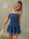 Front three-quarter view of medium-wash denim mini dress with floral scalloped hem