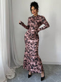 Elevate your fall evening wardrobe with this stunning floral print high-neck fishtail maxi dress. Crafted from a luxurious knitted fabric blend of 93% polyester and 7% elastane, this dress offers medium stretch comfort without compromising on elegance. The sophisticated design features a high round neckline, long sleeves, and a flattering slim-fit silhouette that hugs your curves beautifully. The signature mermaid hem with ruffle detailing and strategic ruching creates a dramatic.