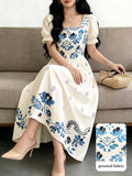 Front seated view of ivory floral midi dress with square neck puff sleeves and printed skirt