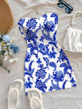 Blue and white floral strapless mini dress laid flat with beach accessories