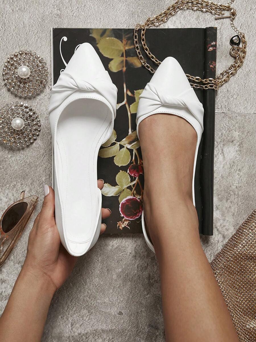 White knot flats with D’Orsay side cutouts and low heel