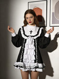Front view of black and white gothic cosplay mini dress with cross bib, layered ruffles and lace hem