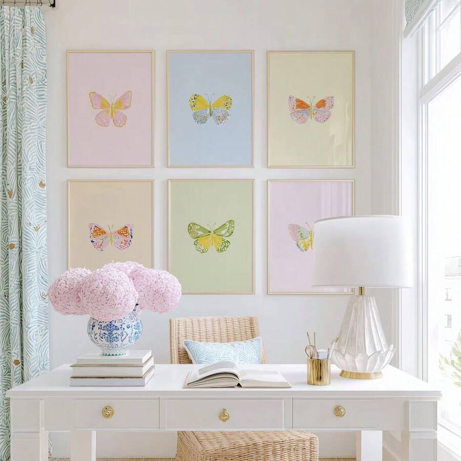 Six framed pastel butterfly prints above a white desk in a bright feminine home office