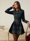 Front three-quarter view of navy and green tartan long-sleeve mini dress with pleated skirt
