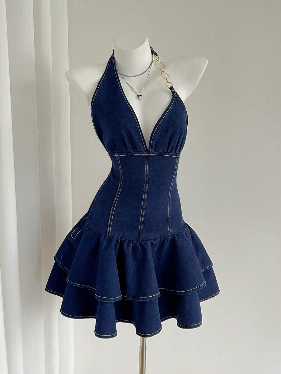 Front mannequin view of dark-indigo halter mini denim dress with gold ring-chain strap and tiered ruffle skirt