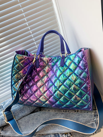 Catch the light and turn heads with this eye-catching holographic quilted top handle bag. The shimmering, iridescent finish shifts with every angle, making it the ultimate statement piece for anyone who loves bold style. Quilted detailing adds texture and dimension, while the sturdy top handle keeps your essentials secure and stylish. Whether you're heading to brunch, a night out, or just running errands, this bag brings that fun, futuristic vibe to any outfit. Compact yet spacious enough for your daily mus