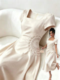 Front view of ivory square neck puff sleeve A-line midi dress with flared skirt and fitted bodice