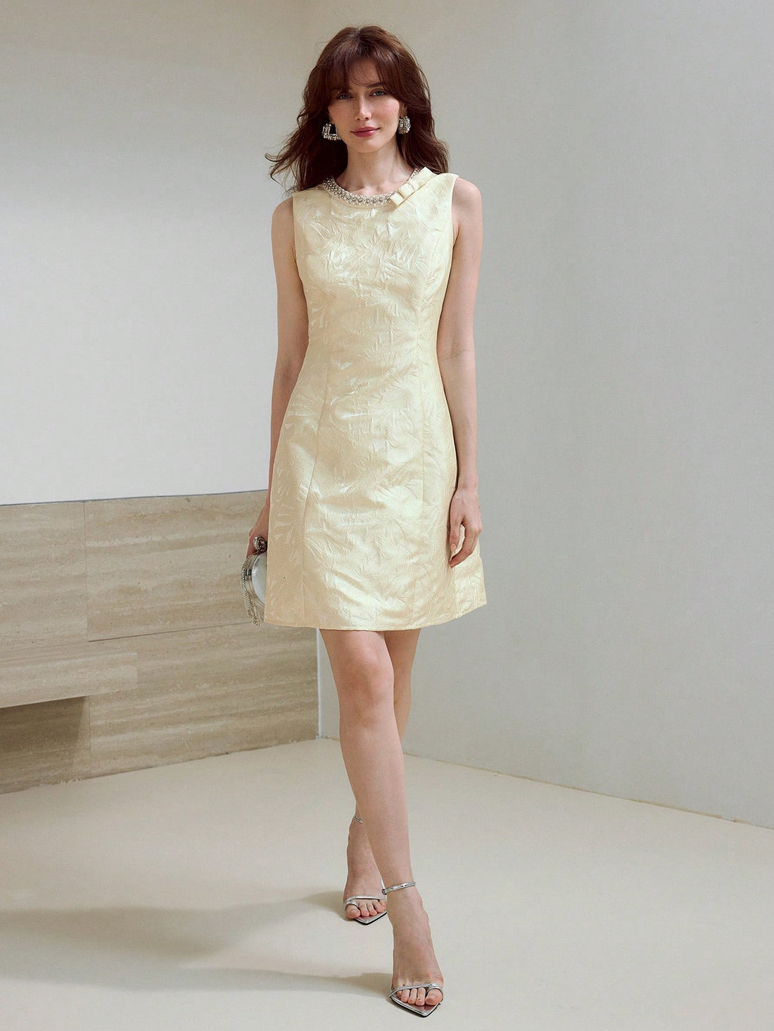 Turn heads with this playful jacquard dress featuring a sparkling rhinestone and faux pearl bow detail. Its sleeveless, short design keeps things flirty and fun, perfect for dancing the night away or making a stylish statement at any event. Embrace charm and confidence in one chic package!