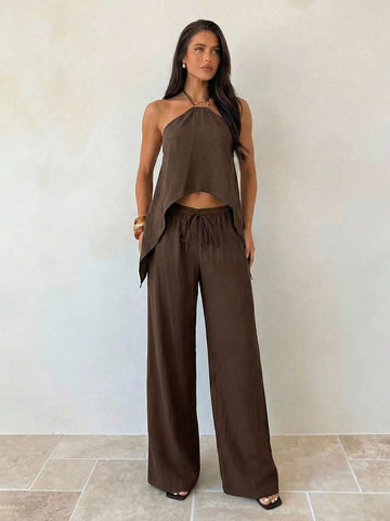 Effortless style meets everyday comfort with this khaki minimalist 2-piece set. The backless camisole features a sleek, modern silhouette perfect for layering or wearing solo, while the loose-fitting long pants provide relaxed movement and a flattering drape. 
