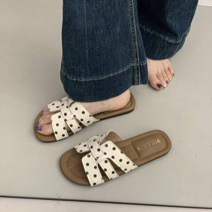4 media show woven-look flat slide sandals in cream with black dots and black with white dots, interlaced H-style vamp straps, open cutouts, backless slip-on, brown padded METWO footbed and thin black outsole. image 1