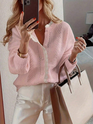 Front three-quarter view of baby pink lace knit cardigan styled with white trousers for daily wear