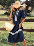 Front three-quarter view of navy lace-trim denim midi dress with puff sleeves for country outings