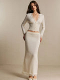Front view of an ivory lace-trim button cardigan and matching long knit skirt set on a model