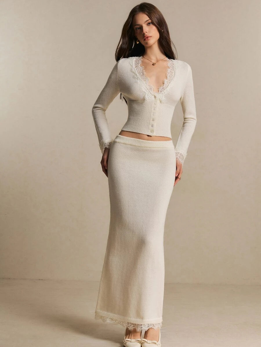 Front view of an ivory lace-trim button cardigan and matching long knit skirt set on a model