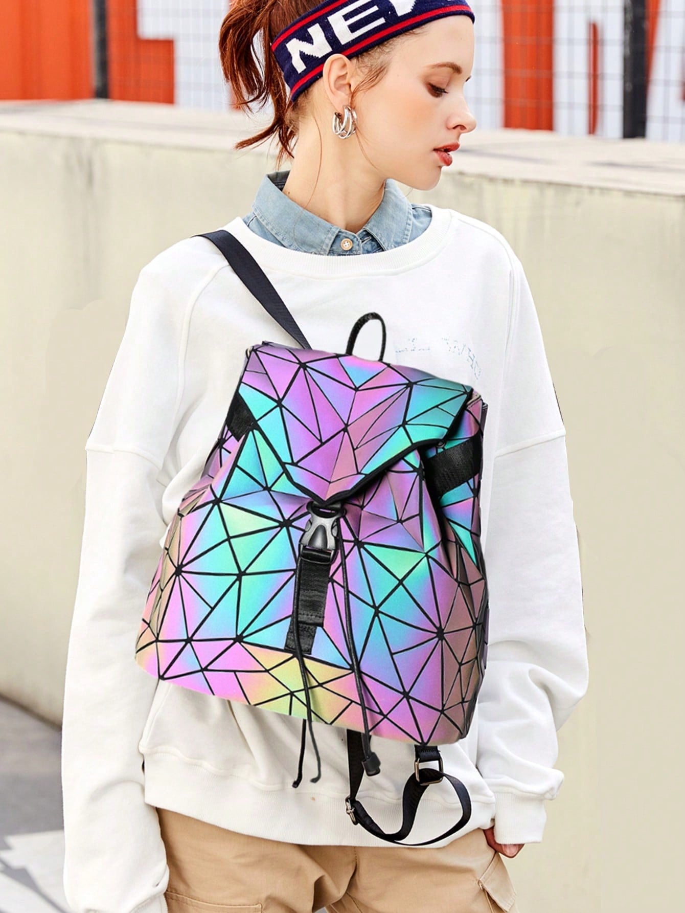 Experience the magic of the Luminous Aura backpack. Its geometric holographic design will turn heads and make you stand out in a crowd. With its shoulder strap, this bag is perfect for any on-the-go adventure. Stay organized with its spacious interior and multiple pockets. 