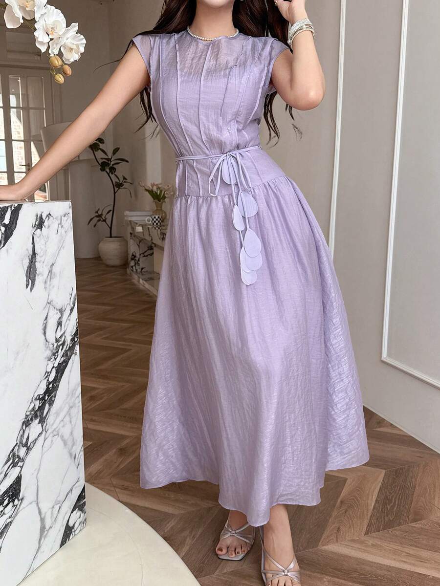 Front view of pale lilac belted A-line maxi dress in elegant interior