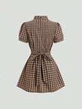 Rear view of brown plaid A-line mini dress with short puff sleeves and tie-back bow
