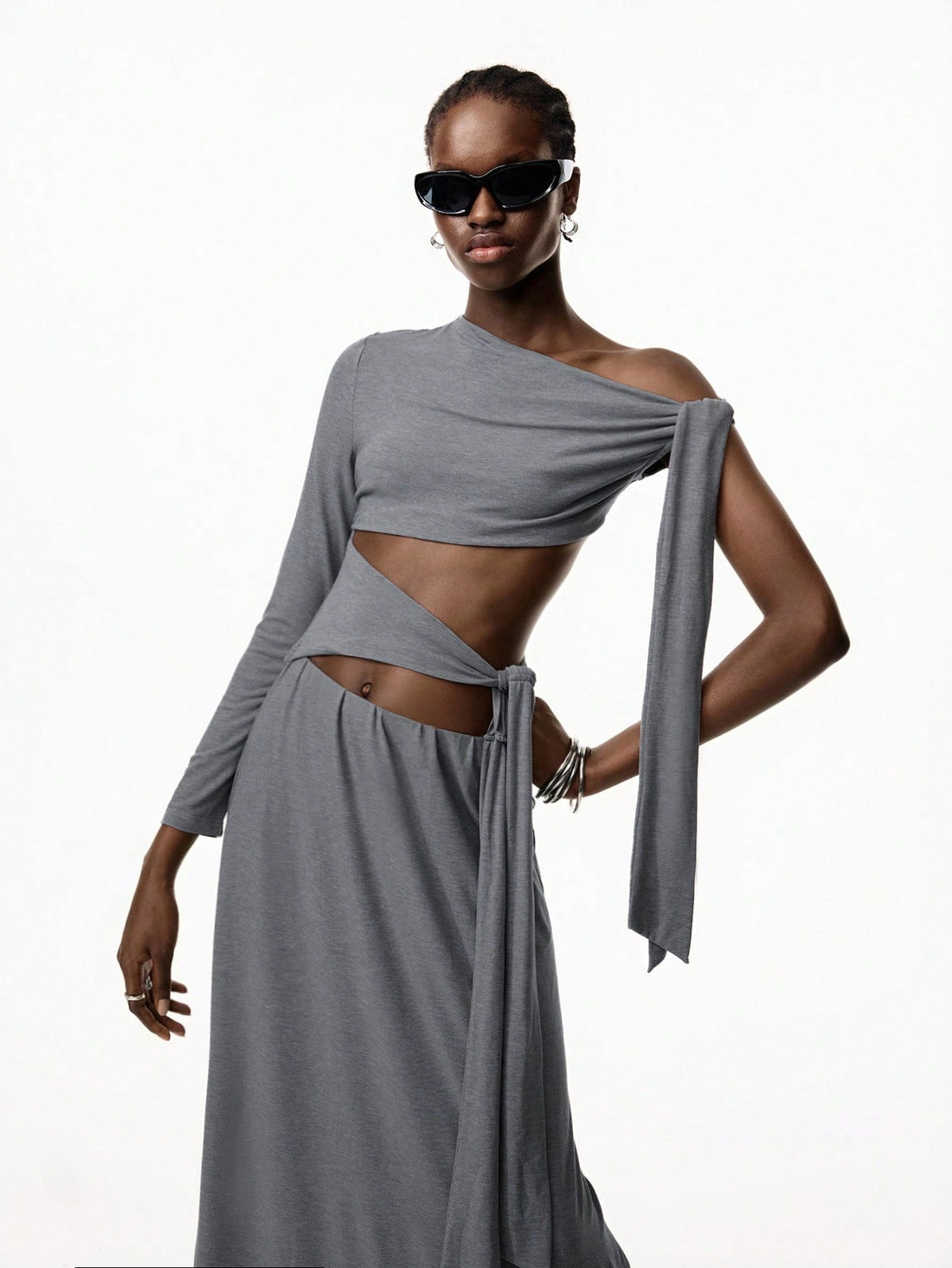 Step into the spotlight with this Minimalist Gray Hollow Strap One-Piece Dress, perfect for Y2K-inspired nightclub vibes or a chic vacation look. Its sleek design and subtle cutouts add a flirty edge while keeping things effortlessly cool. Whether dancing the night away or strolling seaside, this dress blends comfort and style with a playful twist.