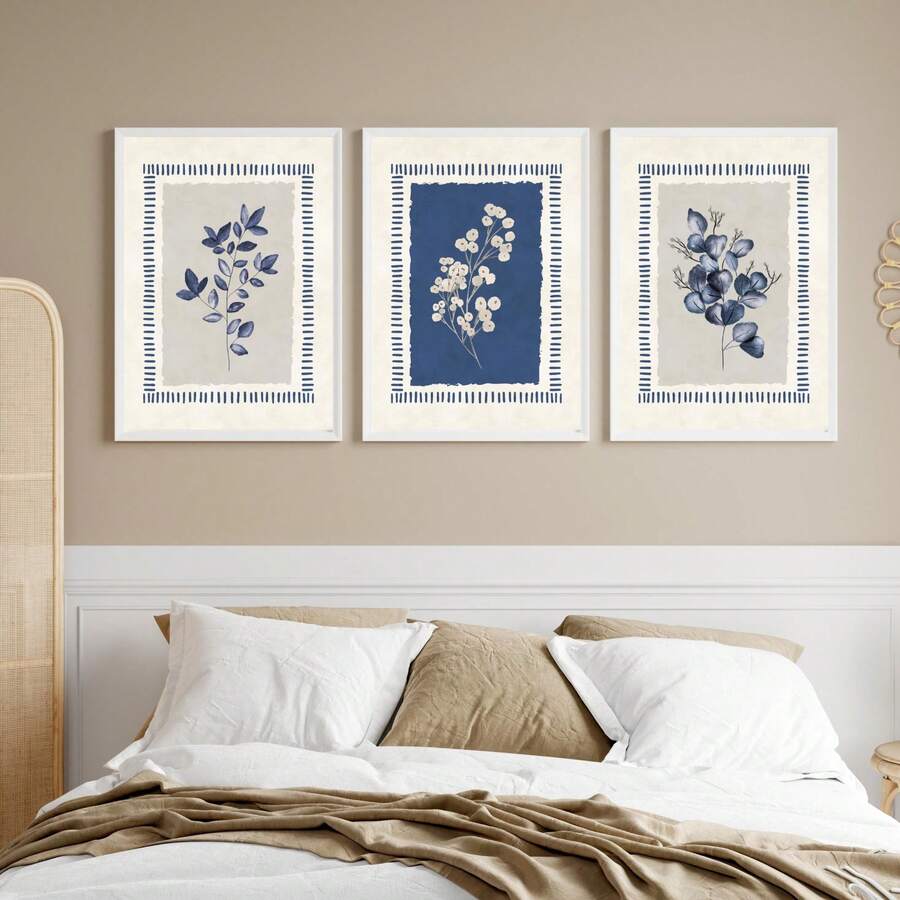 Front bedroom wall mockup of three indigo botanical prints in white frames above a neutral bed