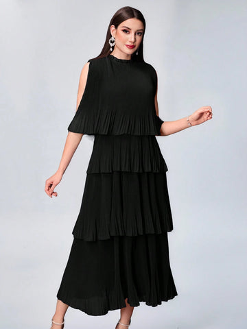 A woman modeling a sleeveless black midi dress with a tiered ruffled skirt and shoulder cutouts, photographed against a light gray studio background.