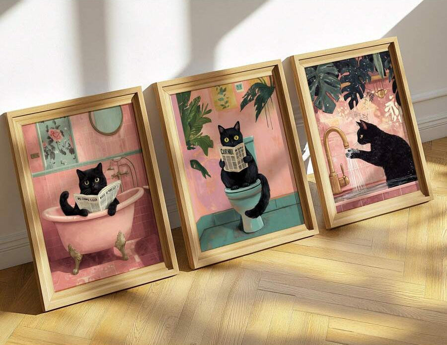 Three pink and teal black cat bathroom art prints in light wood frames