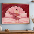 Front view of pink woman reading canvas art in brown frame above a wood cabinet