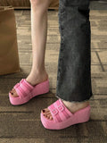 Pink double buckle sandals worn on foot showing chunky wedge height and slip-on fit