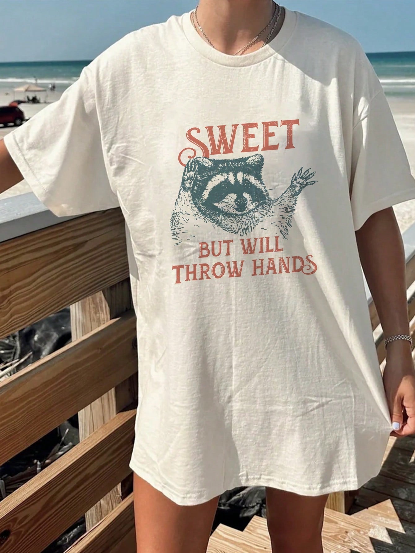 Get ready for some playful fun with our Playful Raccoon Graphic Tee! This cute oversized Y2K beach shirt is perfect for trendy women looking to stand out with a touch of quirkiness. With a playful raccoon design, this tee is sure to add a unique twist to your wardrobe. Don't miss out, grab yours today!