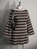 Front view of brown striped knit mini dress on mannequin with long flared sleeves and shoulder bag