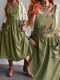 Front view of army green floral embroidered pinafore dress with patch pockets