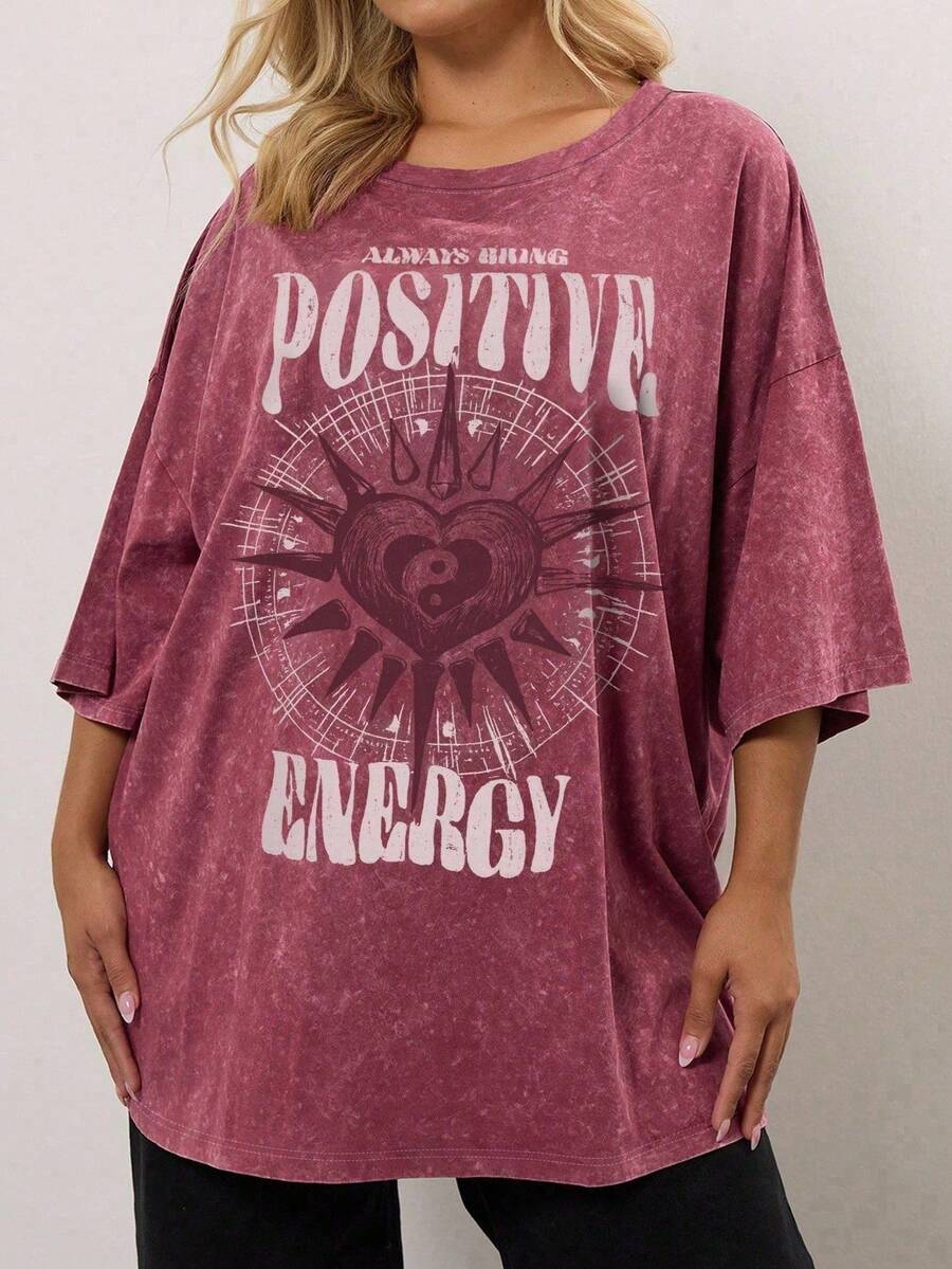 Front model view of burgundy acid wash plus size positive energy graphic tee with heart print