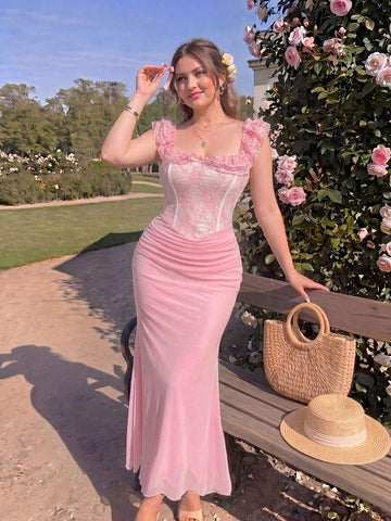 Model wearing blush pink mermaid maxi dress with ruched straps beside roses
