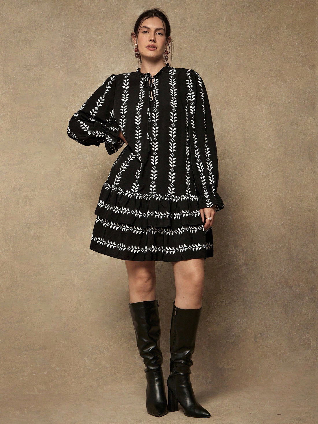 Make a statement with this playful plus-size dress that brings together bold geometric prints and charming details. The tie collar adds a flirty touch while long sleeves provide comfortable coverage, perfect for transitioning between seasons. A ruffled hem gives you that extra dash of personality and movement. Whether you're heading to brunch or a casual day out, this dress celebrates your curves with style and confidence. Effortlessly chic and undeniably fun.