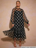 Front view of black and white polka dot long dress with sheer bishop sleeves and gathered flounce hem