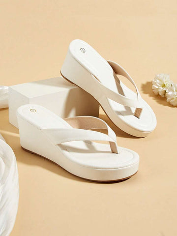 White wedge thong platform sandals on beige studio set with flowers