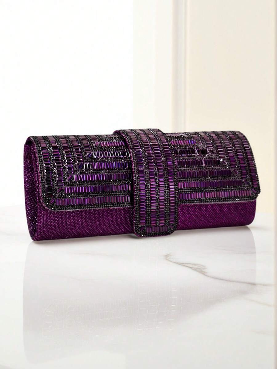 Purple embellished evening clutch on marble surface with curved flap and central rhinestone strap