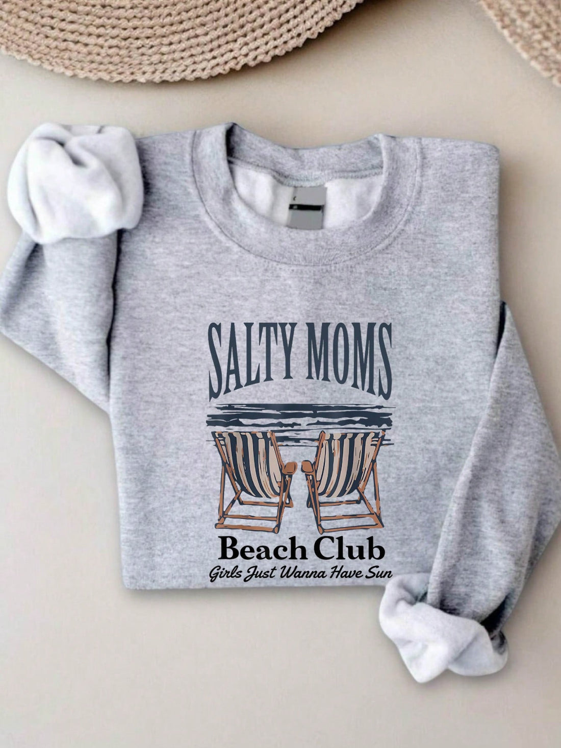 Celebrate your sunny spirit with the Salty Moms Beach Club Sweatshirt! This fun long sleeve sweater is perfect for moms who love the beach and the sun. Cozy and playful, it’s designed to keep you comfortable while showing off your beach club pride. Whether you're chasing waves or relaxing poolside, this sweatshirt adds a splash of fun to your casual wardrobe.
