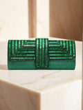 Emerald green rhinestone evening clutch on marble pedestal with geometric beaded flap