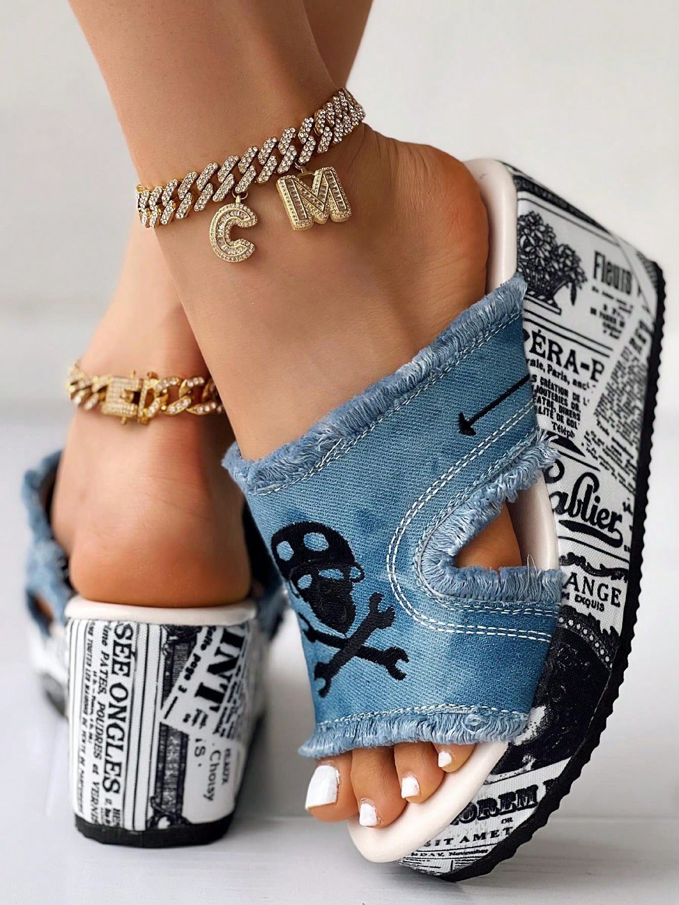 These stylish wedge sandals feature a unique skeleton newspaper print design, perfect for adding a touch of glam to your Halloween look. The comfortable wedge heel provides a subtle lift while the print adds a fun and playful element. Make a statement this Halloween with these must-have sandals.