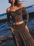 Front beach view of brown off-shoulder knit top and ruffle hem maxi skirt two-piece set