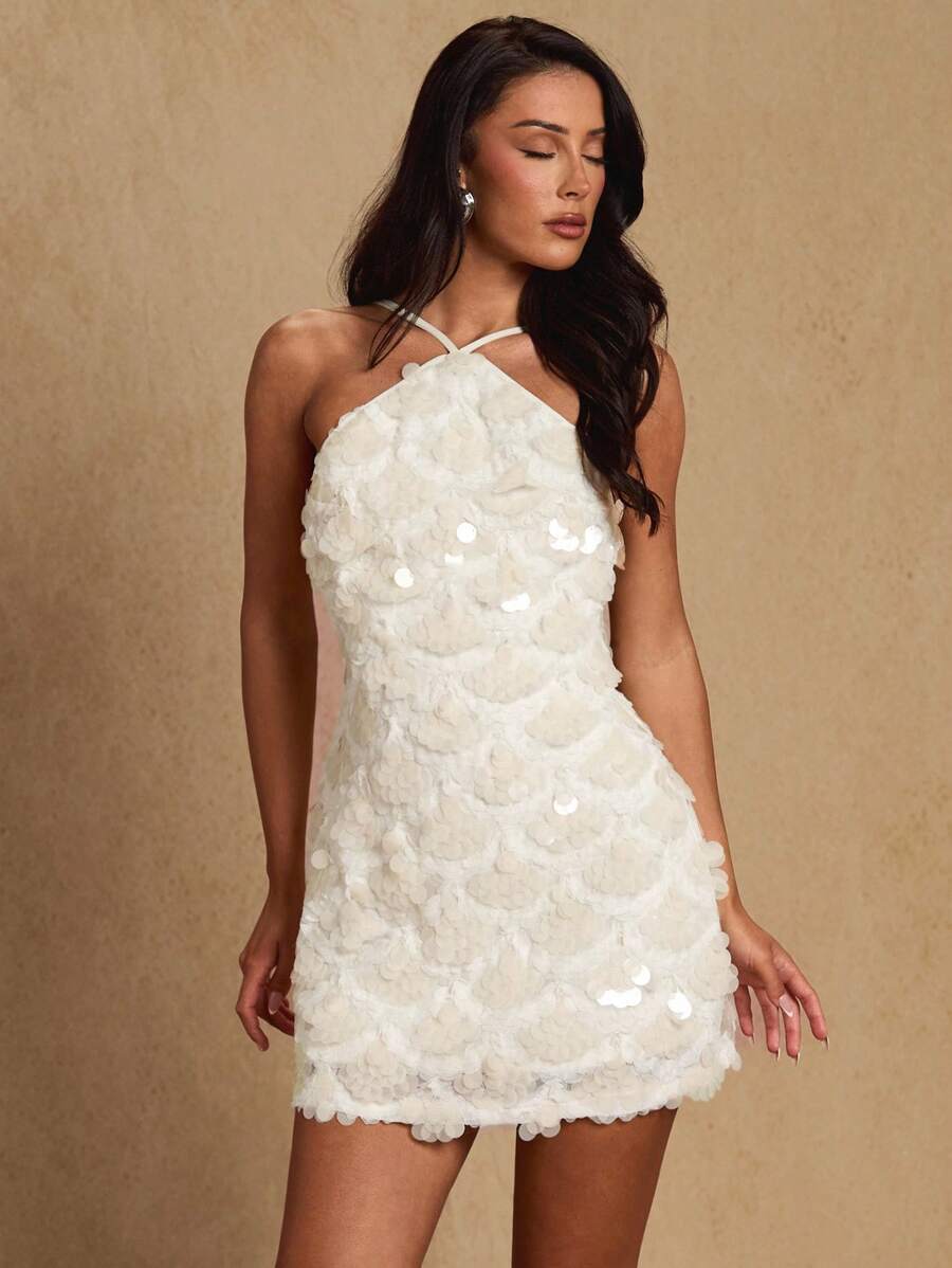 Turn heads at your next night out in this stunning backless halter mini dress that's pure glamour. The allover sequin detailing catches the light with every move, creating a dazzling effect that demands attention. The daring backless design and halter neckline offer a flirty, confident silhouette perfect for parties, clubs, or any occasion where you want to make a statement. Slip it on and let your inner sparkle shine through!