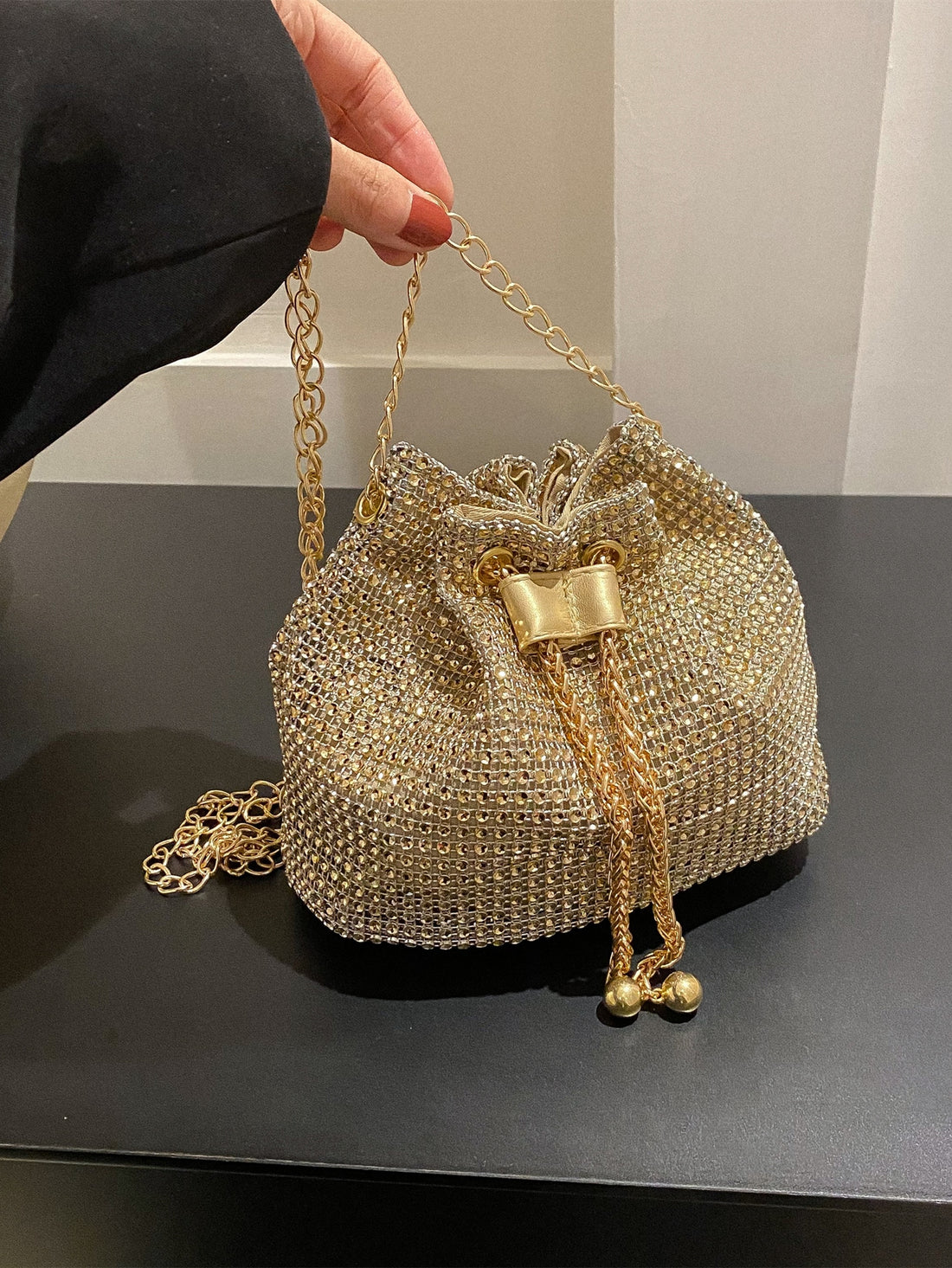 Get ready to dazzle with the Sparkling Elegance mini bucket bag. This glamorous bag features a drawstring closure and is adorned with shimmering rhinestones, making it the perfect accessory for any bridal or evening look. Elevate your style with this stunning and elegant piece.
