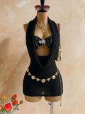 Black open-weave hooded mini dress on mannequin with black sequin shell bra, gold sunburst hardware, shell chain belt