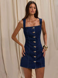Front view of dark indigo square-neck sleeveless denim mini dress with gold-tone buttons