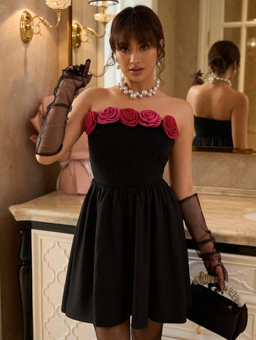 Front view of black strapless mini party dress with dimensional rose trim and flared skirt