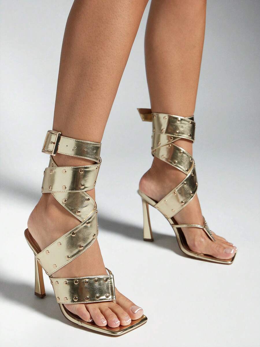 Gold studded spiral-wrap stiletto sandals with square toes and buckle ankle straps