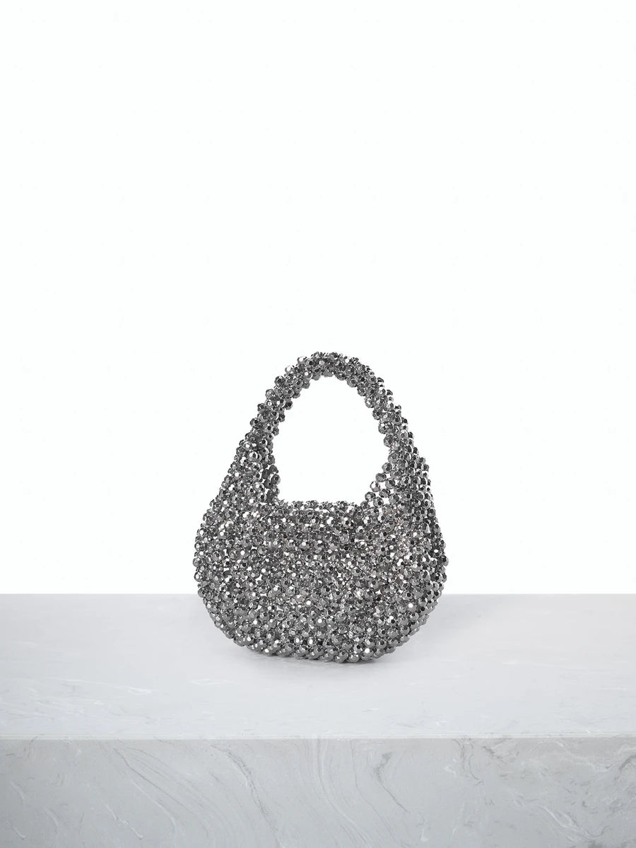 Elevate your evening look with this exquisite handmade beaded mini clutch. Crafted with meticulous attention to detail, this silver novelty bag features a textured beaded design that catches the light beautifully. The compact size fits essentials perfectly, while the top handle ensures easy carrying. Its minimalist aesthetic and flap closure make it an ideal accessory for autumn and winter celebrations, from cocktail parties to formal gatherings. A sophisticated statement piece that transforms any outfit.