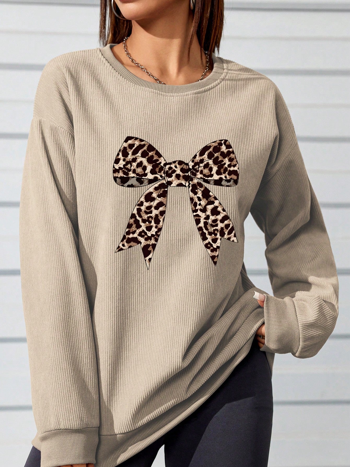 This leopard print sweatshirt is a must-have for any stylish autumn wardrobe. The unique bow detail adds a touch of playful charm to the classic print, making it a versatile piece for any occasion. Stay cozy and on trend with this stylish sweatshirt.